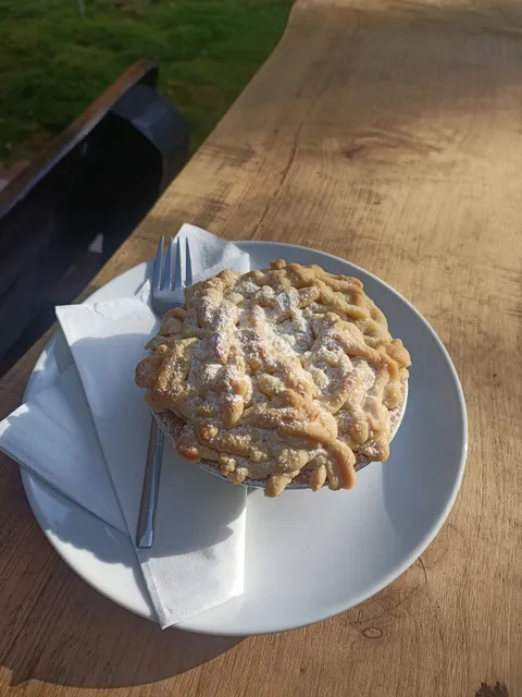 Apple crumble pie with a golden lattice top and icing sugar