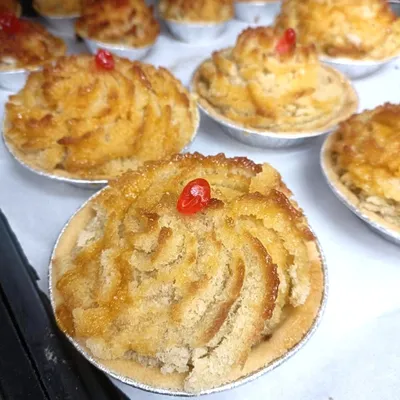 Baked coconut tarts with glacé cherries