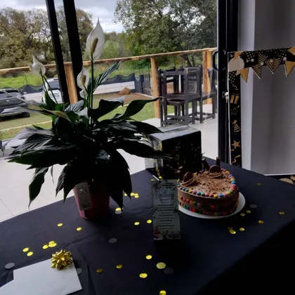 A birthday cake on a decorated table by the window